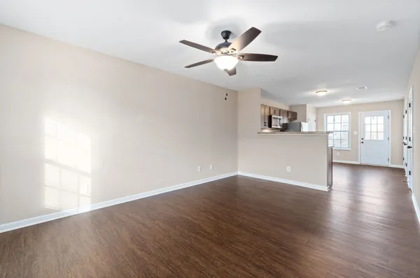 a view of a livingroom with a kitchen counter tops and wooden floor