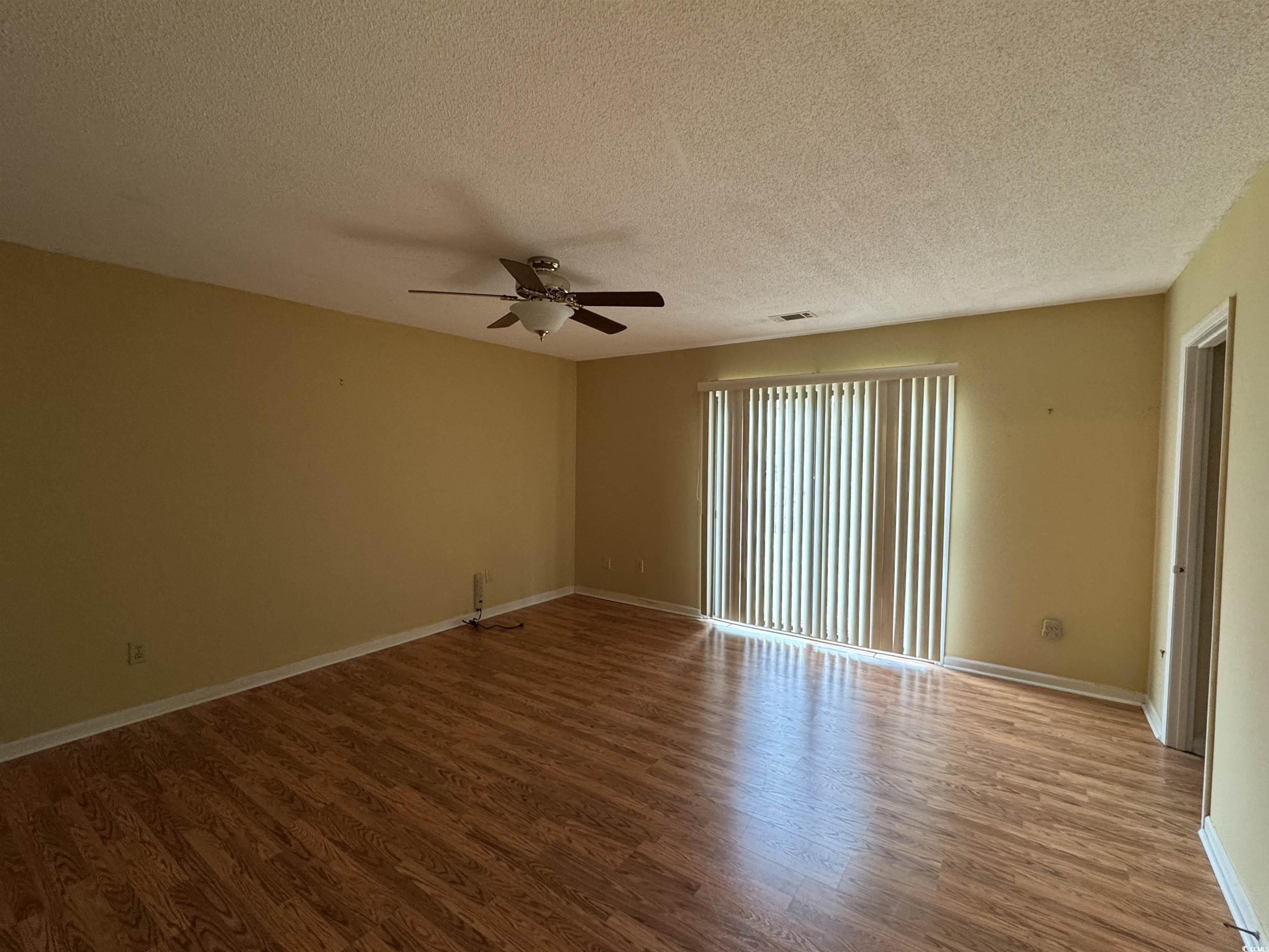 58 Wedgefield Village Road, Unit 48 Georgetown, SC 29440 - Photo 19 of 23 Spare room with a textured ceiling, wood finished floors, and a ceiling fan