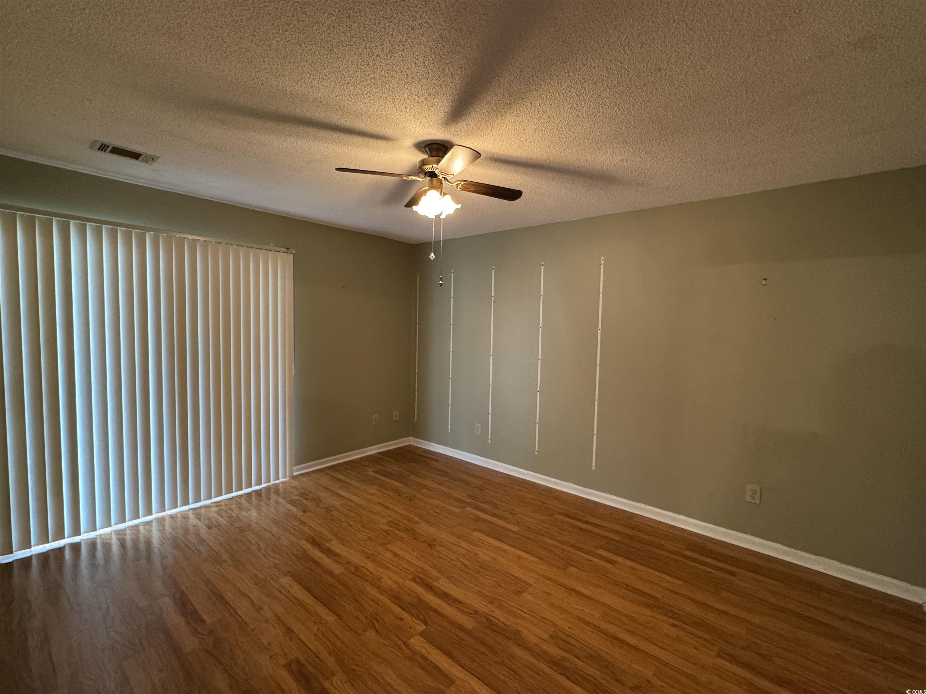 58 Wedgefield Village Road, Unit 48 Georgetown, SC 29440 - Photo 21 of 23 Spare room featuring dark wood-type flooring, a textured ceiling, and ceiling fan