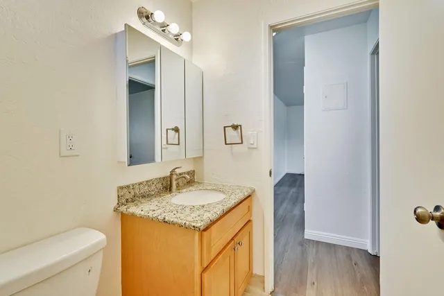 a bathroom with a granite countertop sink and a mirror