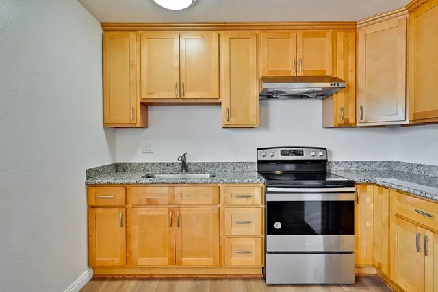 a kitchen with stainless steel appliances granite countertop a stove a sink and a microwave