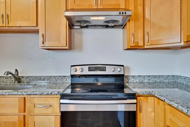 a stove top oven sitting inside of a kitchen