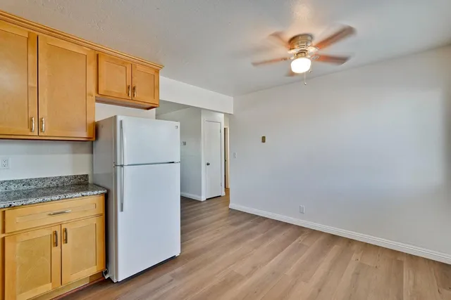 a kitchen with a refrigerator a stove cabinets and wooden floor