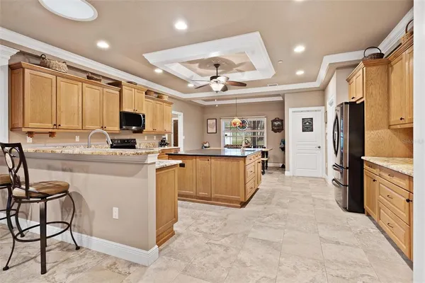 a kitchen with granite countertop a refrigerator and cabinets