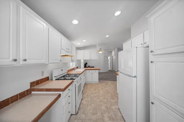 a kitchen with a refrigerator a sink and cabinets