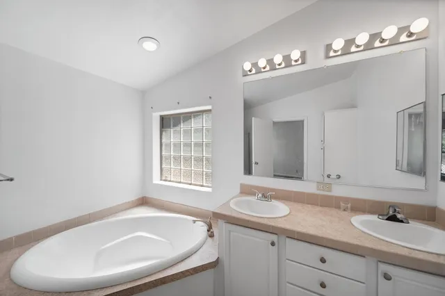 a bathroom with a sink a large mirror and a bathtub