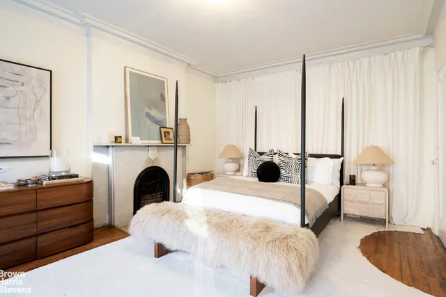 a living room with a large bed and a fireplace