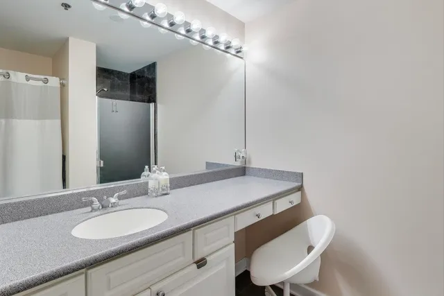 a bathroom with a granite countertop sink a mirror and a toilet