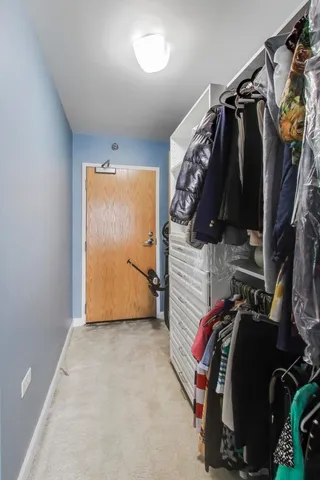 a view of walk in closet with clothes and shoes