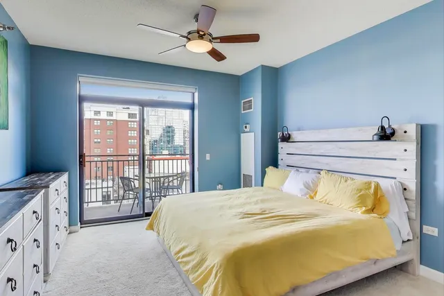 a bedroom with a large bed and a chandelier