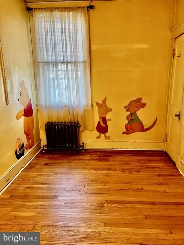 a view of room with a window and hardwood floor