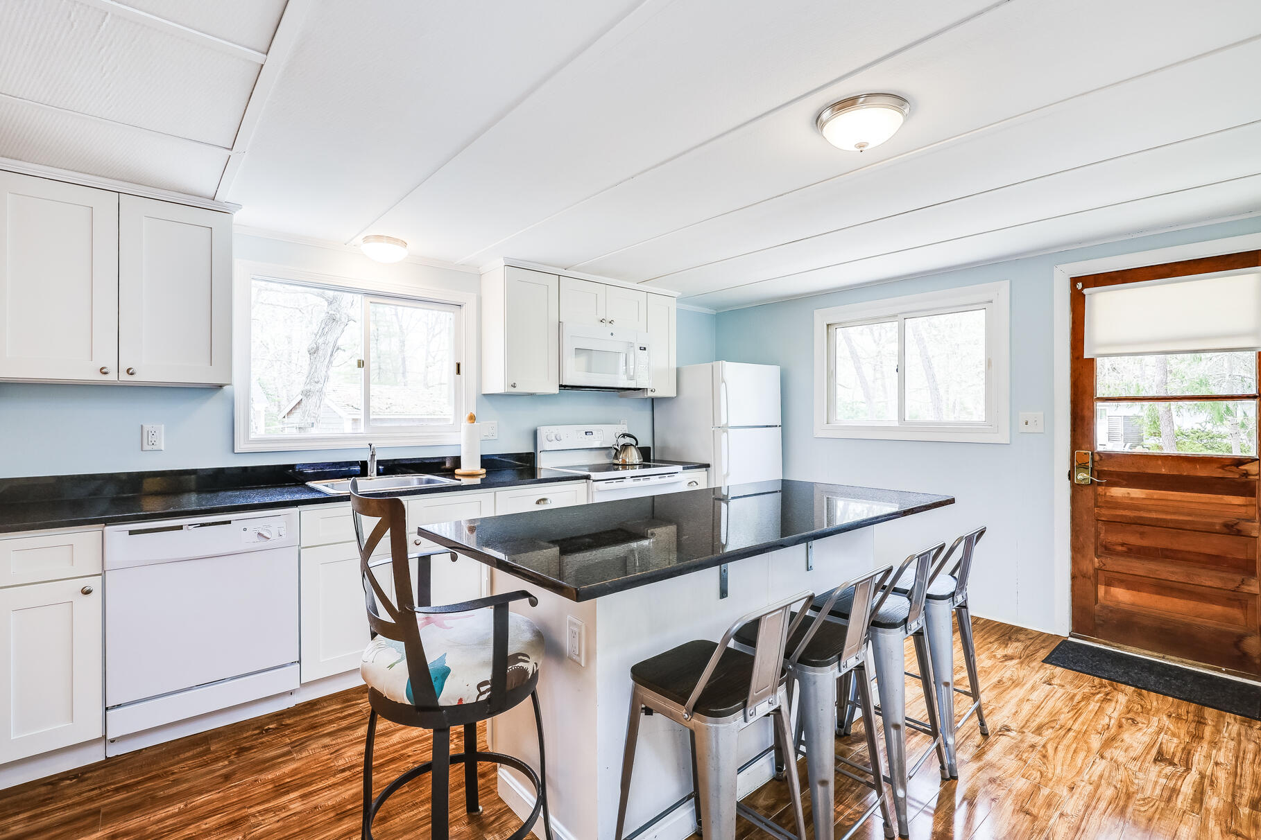 85 Boreen Road Eastham, MA 02642 - Photo 3 of 73 a kitchen with stainless steel appliances granite countertop a stove top oven a sink a dining table and chairs with wooden floor