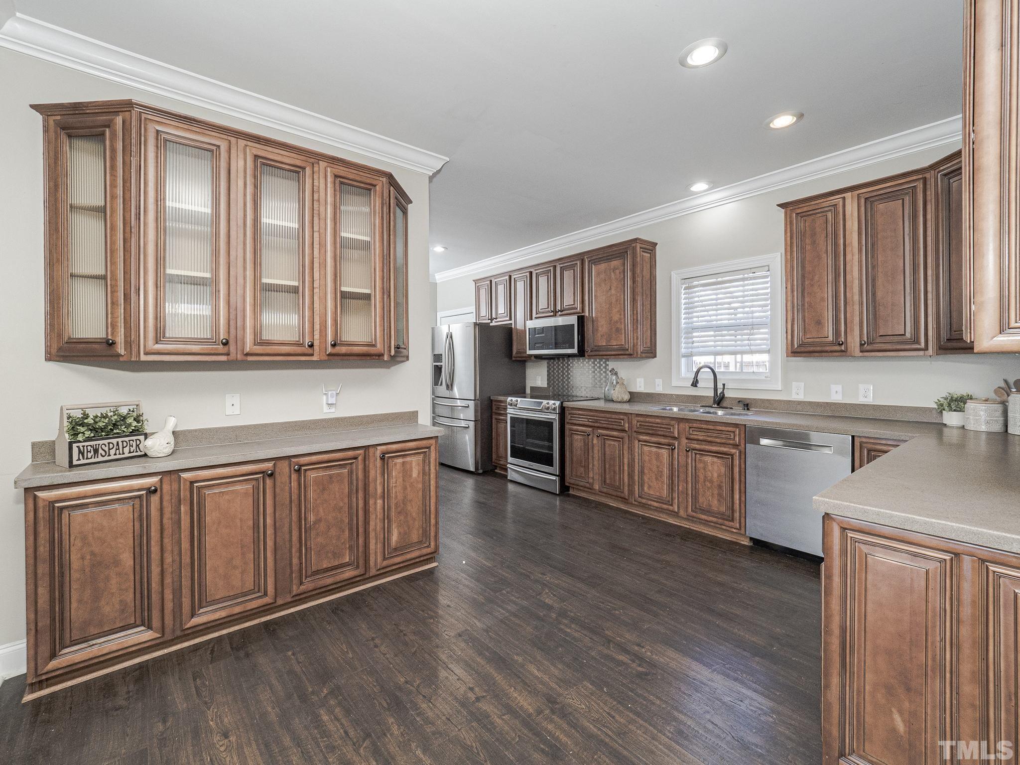 1213 Silver Farm Road Raleigh, NC 27603 - Photo 11 of 27 a kitchen with stainless steel appliances granite countertop a stove a sink dishwasher a refrigerator and cabinets with wooden floor