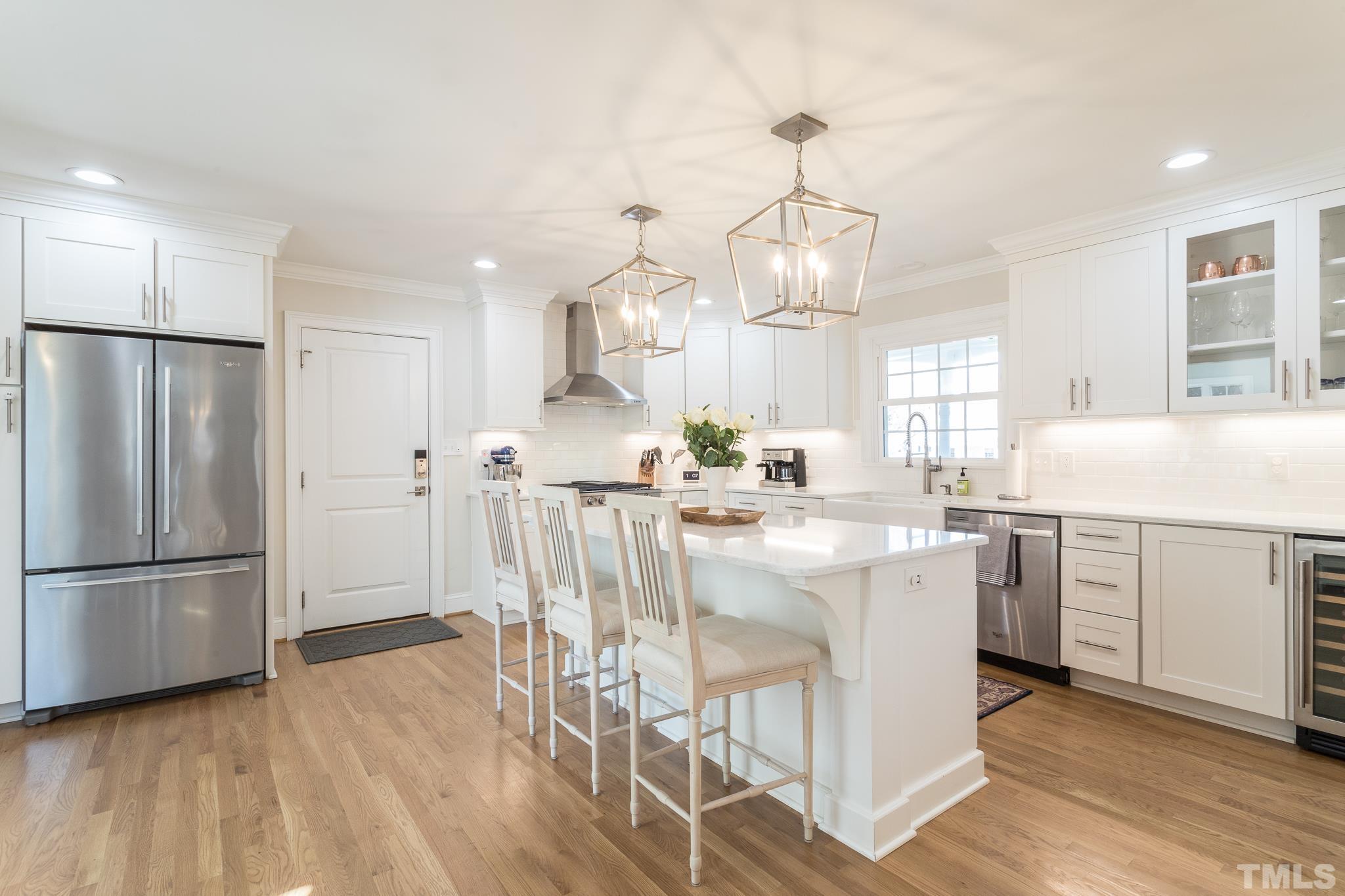 516 Harvard Street Raleigh, NC 27609 - Photo 8 of 31 a kitchen with white cabinets and stainless steel appliances