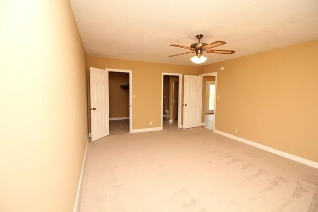 a view of an empty room with a ceiling fan