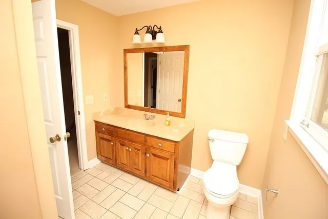 a bathroom with a toilet sink and mirror
