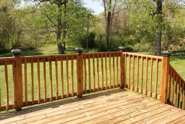 a view of a balcony with wooden floor and fence