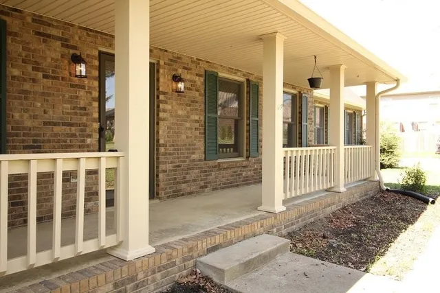 a view of a brick house with wooden fence