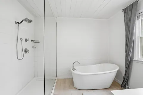 a white bath tub sitting next to a shower