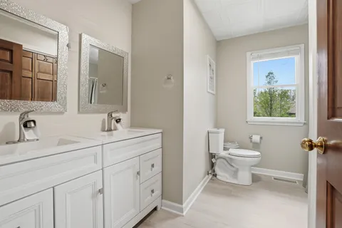 a bathroom with a toilet sink and mirror
