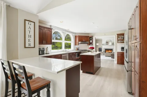 a living room with stainless steel appliances granite countertop furniture and a kitchen view