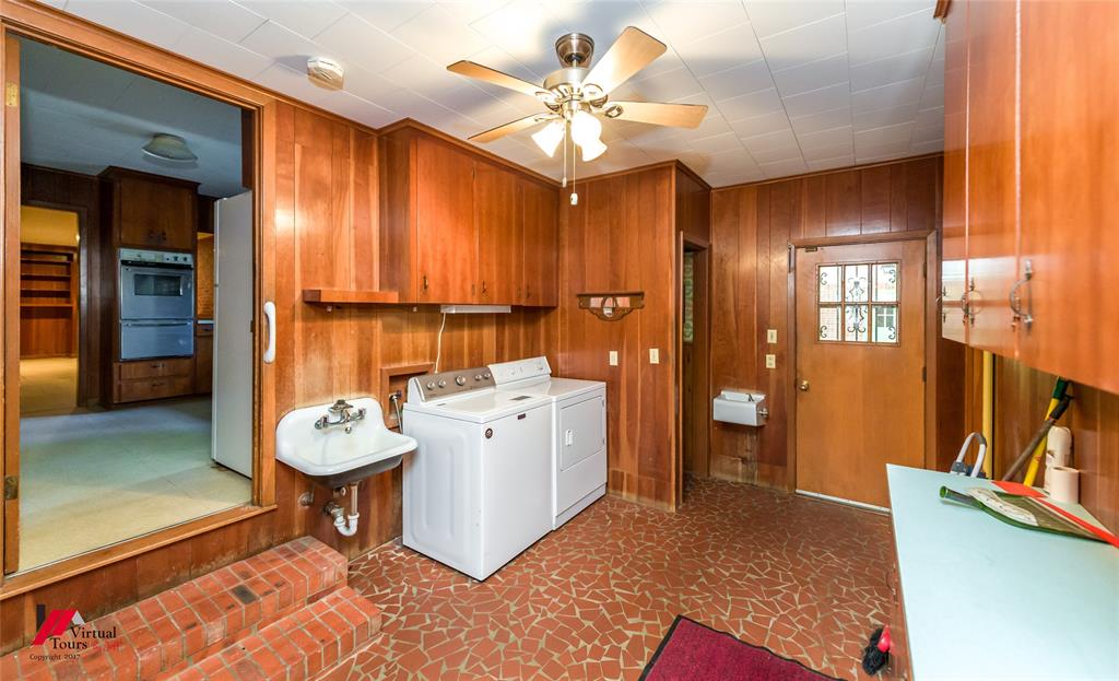 205 7th Street Northeast Springhill, LA 71075 - Photo 8 of 40 Wood paneling, built-in cabinetry, ceiling fan, utility sink, and a decorative glass door