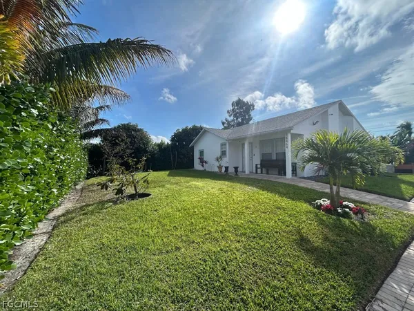 a view of a house with a backyard and a tree