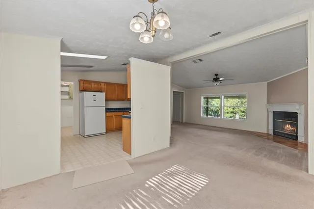 an empty room with fireplace and fan