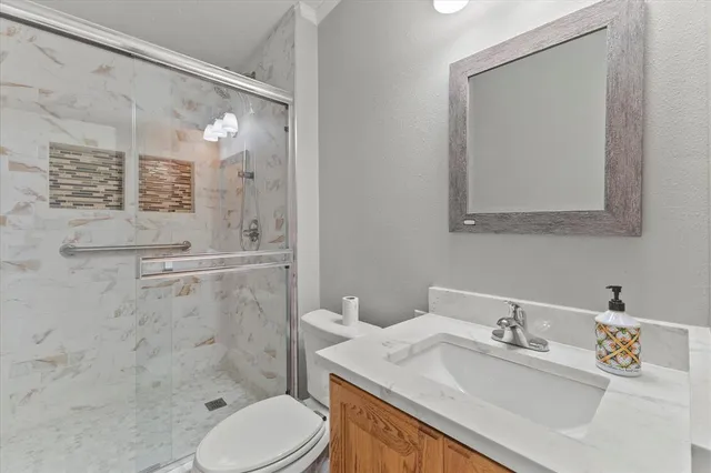 a view of a patio with table and chairs under an umbrella with large trees