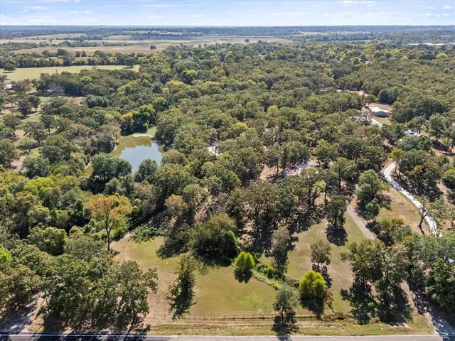 an aerial view of residential houses with outdoor space and trees