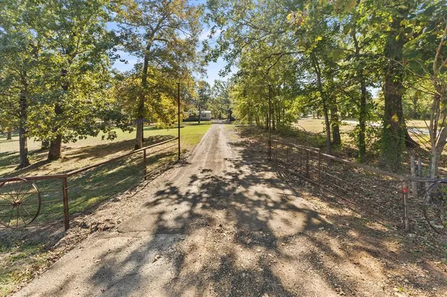 an aerial view of residential houses with outdoor space and trees