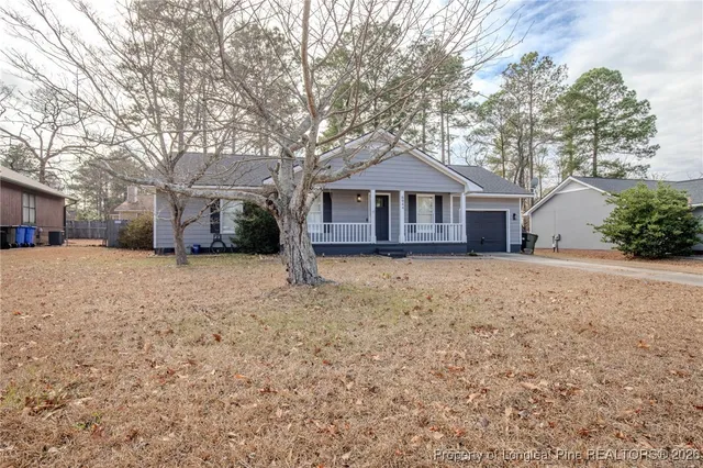 a front view of a house with a yard covered in snow