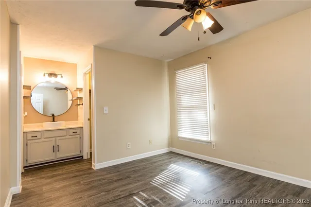 a view of a livingroom with wooden floor and a ceiling fan