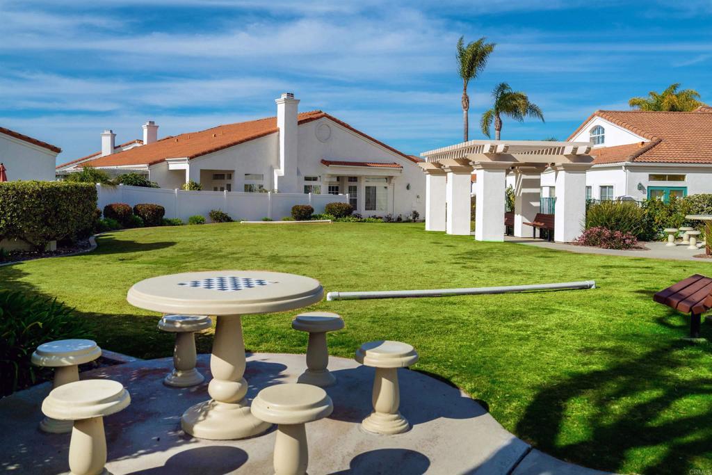3305 Genoa Way, Unit 90 Oceanside, CA 92056 - Photo 31 of 35 a view of a white house with a yard table and chairs