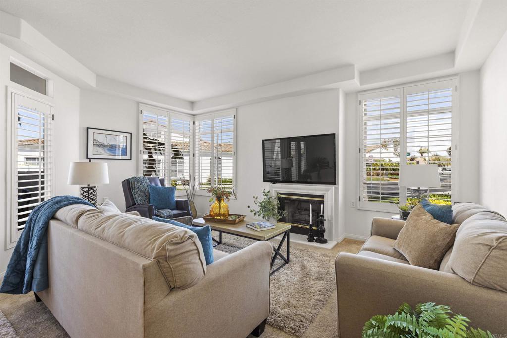 3305 Genoa Way, Unit 90 Oceanside, CA 92056 - Photo 6 of 35 a living room with furniture a flat screen tv and a large window