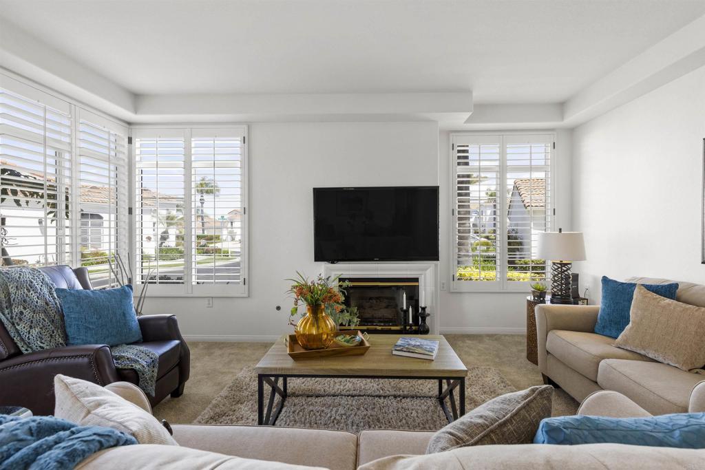 3305 Genoa Way, Unit 90 Oceanside, CA 92056 - Photo 7 of 35 a living room with furniture a flat screen tv and a large window