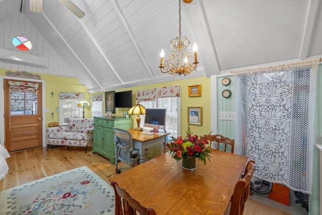 a view of a dining room with furniture a chandelier and wooden floor