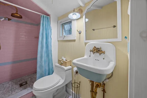 a bathroom with a toilet sink and mirror