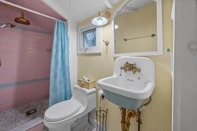 a bathroom with a toilet sink and mirror