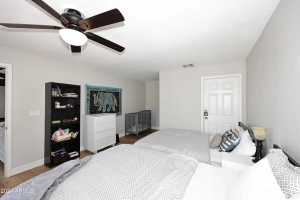 a bedroom with a large bed and a chandelier