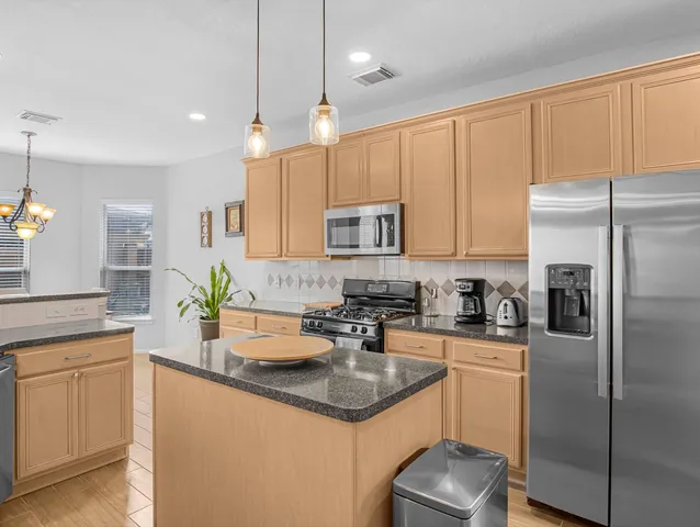 a kitchen with a sink stainless steel appliances and white cabinets