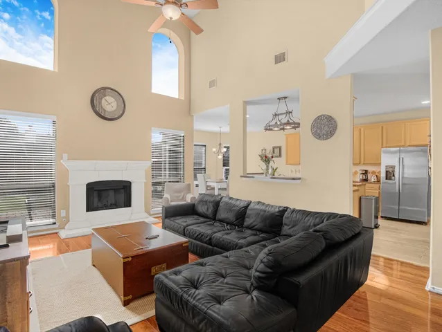 a living room with furniture a fireplace a clock and a window