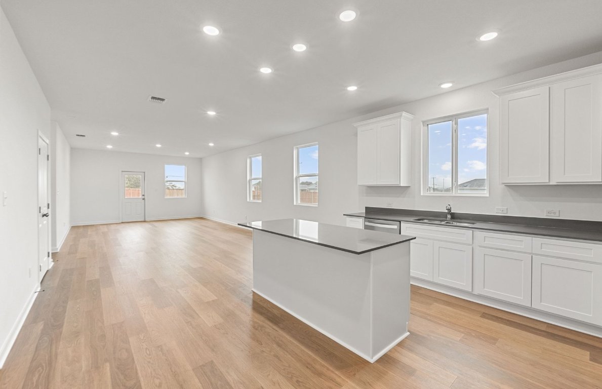 325 Sullivan Way Elgin, TX 78621 - Photo 3 of 19 a large kitchen with stainless steel appliances granite countertop a large counter top a sink and a stove