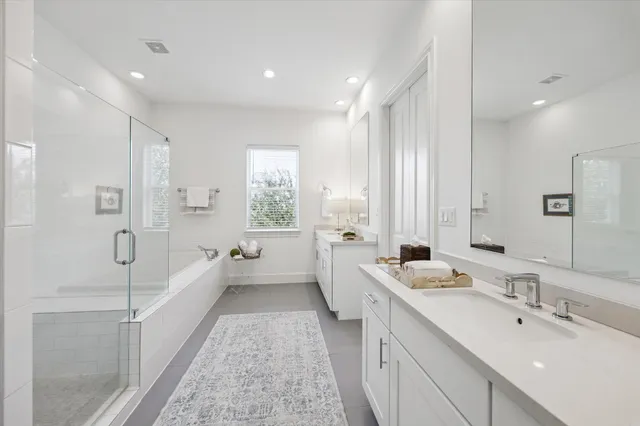 a bathroom with a double vanity sink a mirror and a bathtub