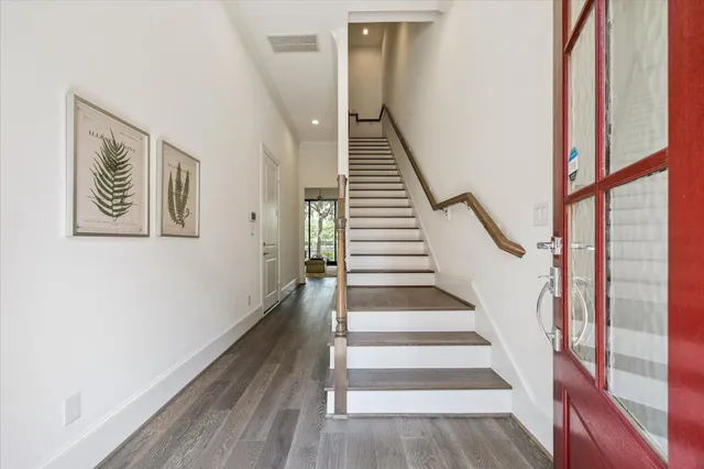 a view of staircase with wooden floor and white walls