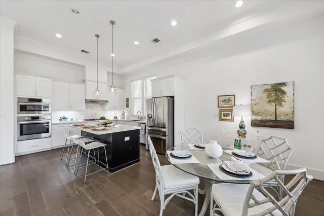 a large kitchen with kitchen island a dining table and stainless steel appliances