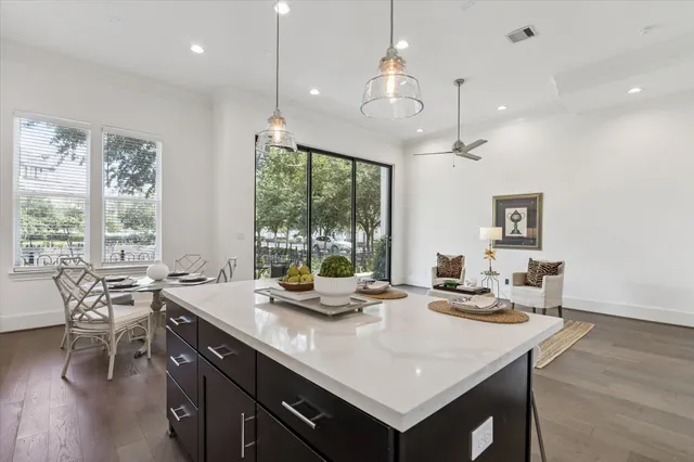 a view of a dining room and livingroom with furniture wooden floor a chandelier
