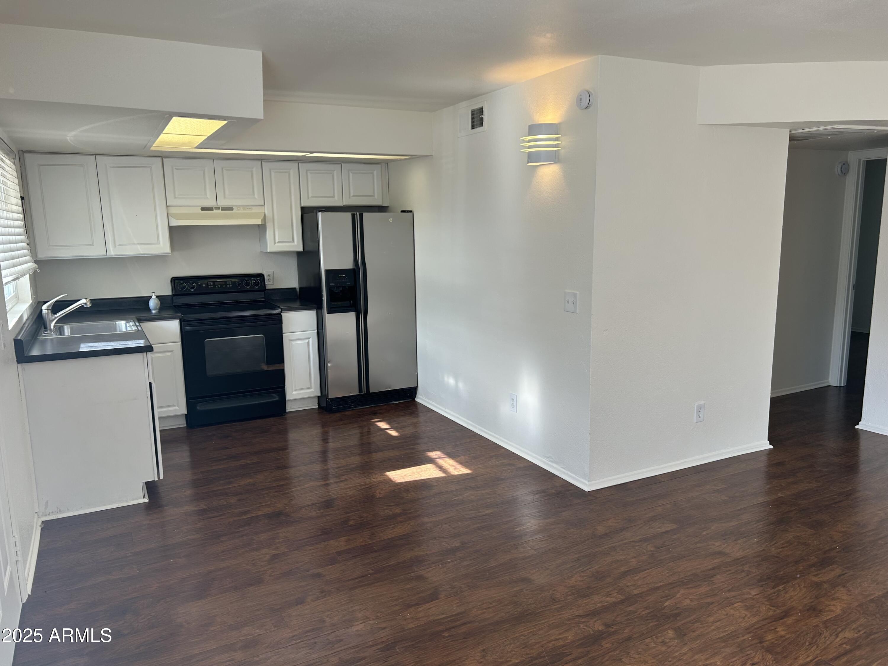 a kitchen with a refrigerator and a stove top oven