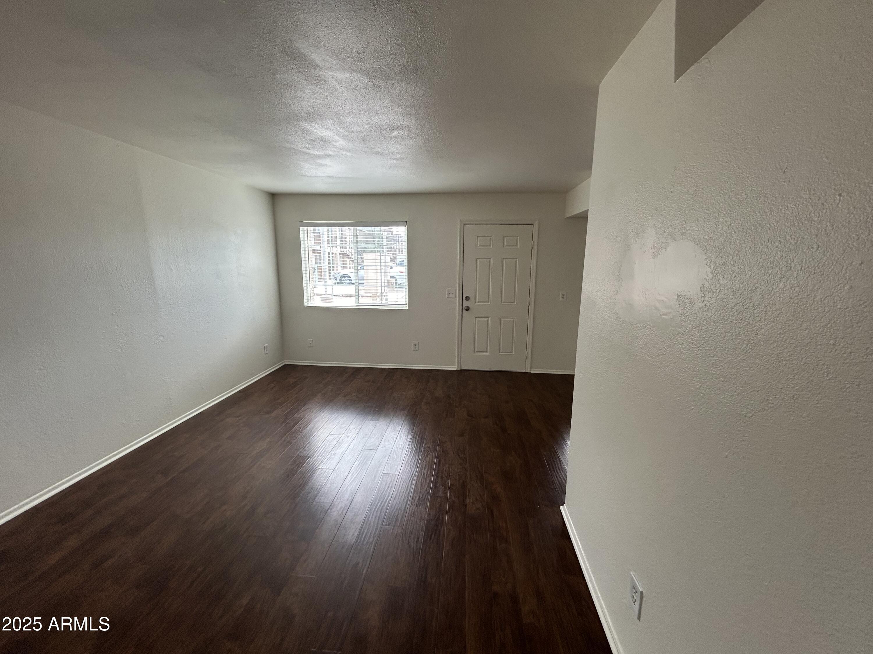 45 North Phyllis, Unit 109 Mesa, AZ 85201 - Photo 11 of 28 an empty room with wooden floor and windows