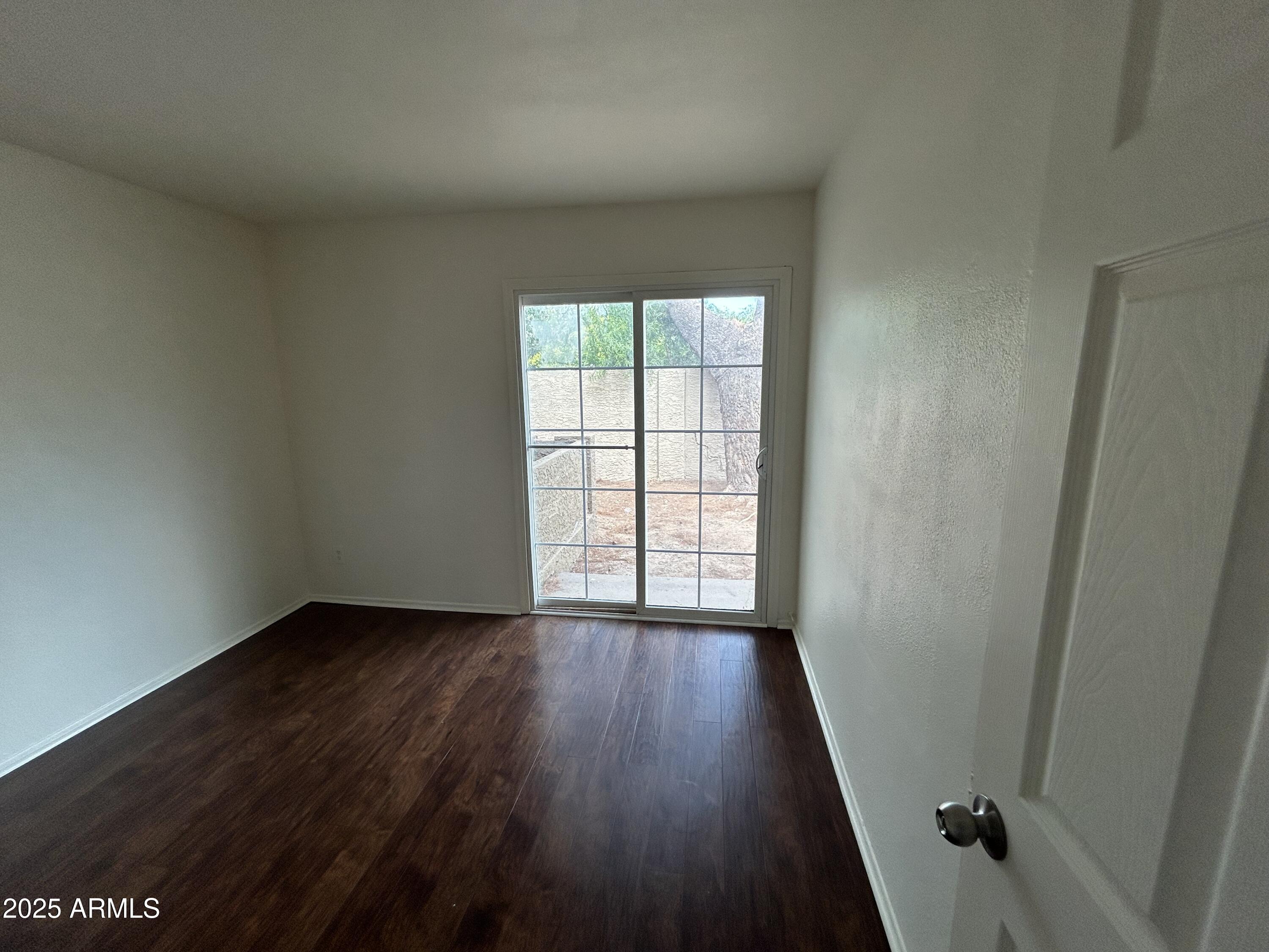 45 North Phyllis, Unit 109 Mesa, AZ 85201 - Photo 24 of 28 an empty room with wooden floor and windows